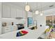 Modern kitchen featuring white cabinets, stainless steel appliances, and a large island with pendant lighting at 813 N Mangum St, Durham, NC 27701