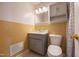 A vintage bathroom features yellow tile, vanity with storage, mirror, updated fixtures and a shower/tub at 817 S Brake St, Nashville, NC 27856
