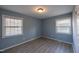 Sunlit bedroom featuring stylish gray walls, durable wood-look flooring, and bright double windows at 817 S Brake St, Nashville, NC 27856