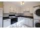Bright kitchen features white cabinets, black countertops, and modern appliances including a washer and dryer at 817 S Brake St, Nashville, NC 27856