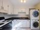 Bright kitchen features white cabinets, black countertops, and modern appliances including a washer and dryer at 817 S Brake St, Nashville, NC 27856