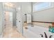 Clean bathroom with a soaking tub, tiled surround, and natural light at 86 Pappy Ln, Garner, NC 27529
