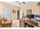 A cozy office featuring neutral tones, a ceiling fan, and a dark wood desk situated beside a comfortable arm chair at 86 Pappy Ln, Garner, NC 27529