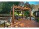 Outdoor brick patio featuring a wooden pergola, grill and seating, ideal for outdoor gatherings and summer grilling at 8600 Paddle Wheel Dr, Raleigh, NC 27615