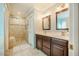 Bathroom features a tiled shower, vanity with double sinks and dark wood cabinets at 8600 Paddle Wheel Dr, Raleigh, NC 27615