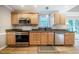 Well-appointed kitchen with stainless steel appliances and wooden cabinetry, offering a cozy atmosphere at 8600 Paddle Wheel Dr, Raleigh, NC 27615