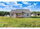 Expansive backyard view of the home with a screened-in porch, patio, and lush green grass at 9315 Turkey Way, Middlesex, NC 27557