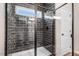 Sleek walk-in shower featuring black-tiled walls with white grout and a frameless glass door at 9315 Turkey Way, Middlesex, NC 27557