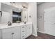 Bathroom with double vanity, dark hardware, mirrors, and tiled shower at 9315 Turkey Way, Middlesex, NC 27557