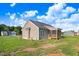 Back view of the home featuring a screened-in porch, lush green grass, and grey siding at 9315 Turkey Way, Middlesex, NC 27557