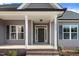Inviting covered front porch with brick steps, white pillars, and stylish lighting. The house number is visible on the siding at 9315 Turkey Way, Middlesex, NC 27557
