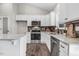 Modern kitchen features white cabinets, granite countertops, stainless steel appliances, and dark backsplash at 9315 Turkey Way, Middlesex, NC 27557