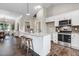 Modern kitchen with a granite island, breakfast bar seating, stainless steel appliances, and white cabinetry, plus dark backsplash at 9315 Turkey Way, Middlesex, NC 27557