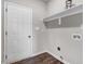 Laundry room features wood-look floors, white door, floating shelf, and grey walls at 9315 Turkey Way, Middlesex, NC 27557
