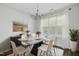 Elegant dining room with a modern table set, chandelier, stylish sideboard and bright natural light at 938 Widewaters Pkwy, Knightdale, NC 27545