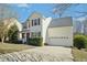 Well-maintained two story home featuring a manicured lawn, a two-car garage and mature landscaping at 938 Widewaters Pkwy, Knightdale, NC 27545