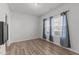 Bright bedroom with wood-look flooring, large windows with gray curtains, and ample natural light at 95 Westbrook Ln, Franklinton, NC 27525