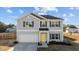 Charming two-story home features gray siding, a bright yellow front door, and an attached two-car garage at 95 Westbrook Ln, Franklinton, NC 27525