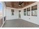 Covered back porch featuring a ceiling fan, wood ceiling, gray deck, and white trim at 100 Sire Ct, Holly Springs, NC 27540