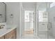 Bathroom features a marble tile shower, vanity with light wood cabinets, and a view into the walk-in closet at 100 Sire Ct, Holly Springs, NC 27540