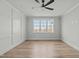 Spacious bedroom with large windows, hardwood floors, and modern ceiling fan at 100 Sire Ct, Holly Springs, NC 27540