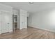 Bedroom featuring hardwood floors, neutral walls, and views into the bathroom and closet at 100 Sire Ct, Holly Springs, NC 27540