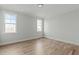 Bright bedroom with hardwood floors, neutral walls, and lots of natural light from two windows at 100 Sire Ct, Holly Springs, NC 27540