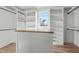 Walk-in closet featuring plenty of shelving and clothing racks, as well as a butcher block island and natural light at 100 Sire Ct, Holly Springs, NC 27540