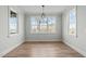 This dining room has a modern chandelier and natural light from the windows, creating a calming atmosphere at 100 Sire Ct, Holly Springs, NC 27540