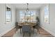 This dining room features a round wood table, grey chairs, and a chandelier. It is beautifully staged at 100 Sire Ct, Holly Springs, NC 27540