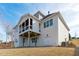 Rear exterior view of the home showcasing white siding, back porches, and freshly seeded lawn at 100 Sire Ct, Holly Springs, NC 27540