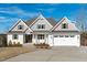 Beautiful two-story white brick home with attached two-car garage and a well-manicured front lawn at 100 Sire Ct, Holly Springs, NC 27540