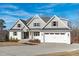 Charming two-story white brick home with a front-facing two-car garage and a well-maintained lawn at 100 Sire Ct, Holly Springs, NC 27540