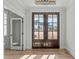 Inviting foyer featuring hardwood floors, a decorative ceiling, and a dark wood double front door at 100 Sire Ct, Holly Springs, NC 27540