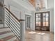 Welcoming foyer featuring wood stairs with iron railing and a dark wood double front door at 100 Sire Ct, Holly Springs, NC 27540
