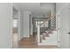 Bright hallway with hardwood floors, a staircase, and white trim, leading to other rooms at 100 Sire Ct, Holly Springs, NC 27540