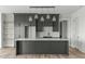 Modern kitchen featuring dark cabinets, stainless appliances, marble backsplash and a center island with pendant lighting at 100 Sire Ct, Holly Springs, NC 27540