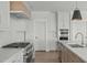Modern kitchen featuring white cabinetry, stainless steel appliances, and a quartz countertop at 100 Sire Ct, Holly Springs, NC 27540