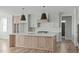 Modern kitchen featuring a large island, stylish pendant lighting, and light wood cabinets at 100 Sire Ct, Holly Springs, NC 27540