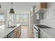 Bright, open kitchen showcasing stainless appliances, a kitchen island, and hardwood floors at 100 Sire Ct, Holly Springs, NC 27540