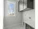 Functional laundry room with modern cabinetry, ample counter space, and a view from the window at 100 Sire Ct, Holly Springs, NC 27540