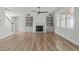 Bright living room features a fireplace with built-in shelving, hardwood floors and a modern ceiling fan at 100 Sire Ct, Holly Springs, NC 27540