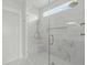 A bright shower is tiled with marble and has glass doors and a rain shower head at 100 Sire Ct, Holly Springs, NC 27540