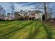 Expansive backyard featuring lush green grass, mature trees, a deck and screened-in porch perfect for outdoor enjoyment at 1004 Colworth Way, Raleigh, NC 27614