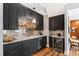 Modern home bar showcasing black cabinets, mirror backsplash, countertop and wine cooler at 1004 Colworth Way, Raleigh, NC 27614
