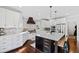 Modern kitchen boasts white cabinetry, hardwood floors, stainless appliances, and a large center island at 1004 Colworth Way, Raleigh, NC 27614