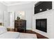 Main bedroom detail featuring a modern fireplace, TV, and a lovely accent table and mirror at 1004 Colworth Way, Raleigh, NC 27614