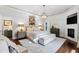 Spacious main bedroom with a fireplace, light-colored carpet and walls, and a designer chandelier at 1004 Colworth Way, Raleigh, NC 27614