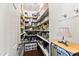A walk-in pantry with bright lighting, wooden shelves filled with food and other supplies, and a wood side table at 1004 Colworth Way, Raleigh, NC 27614