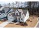 Aerial view of a light blue, two-story home with red shutters, a gray roof, front porch, and two-car garage at 1129 Sequoia Creek Ln, Cary, NC 27519